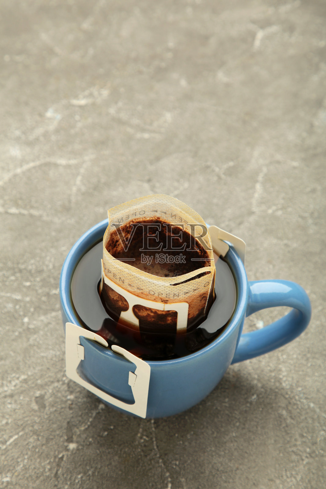 滴咖啡袋与咖啡粉在杯在灰色背景照片摄影图片