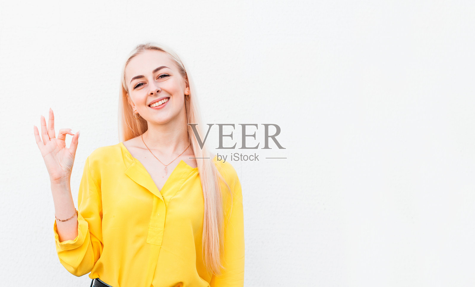 开朗、有趣、可爱的金发女人在打手势照片摄影图片