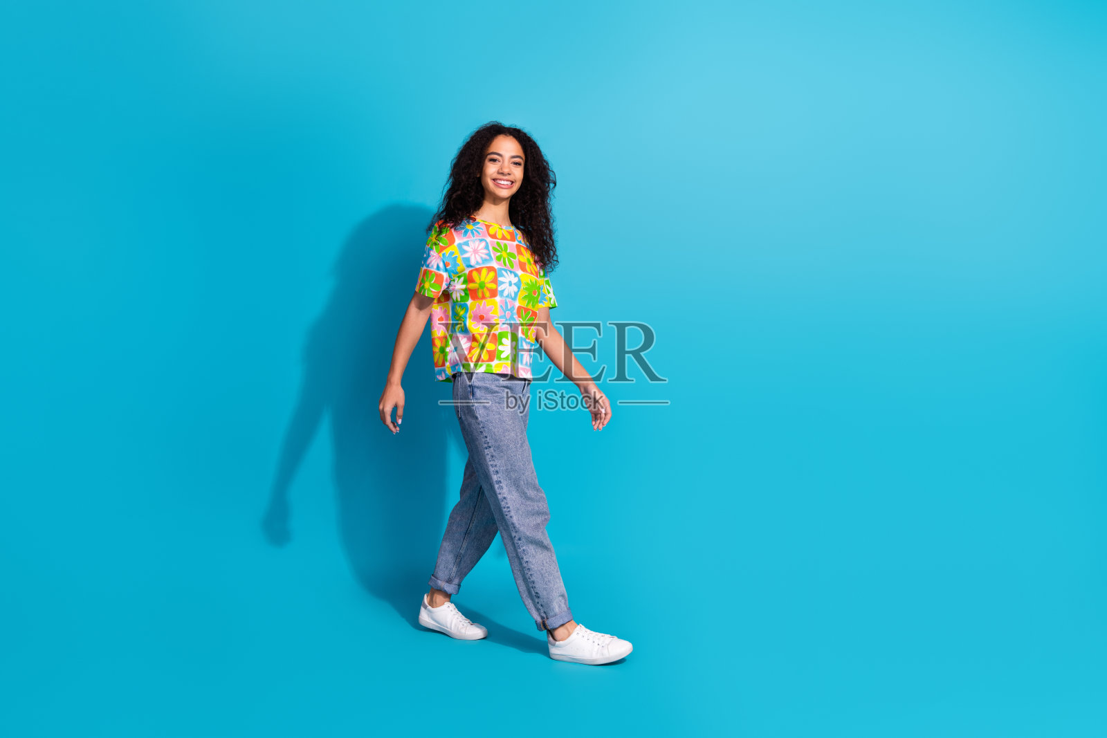 全身照片闪亮迷人的女士穿着印花t恤走空空间孤立的蓝色背景照片摄影图片