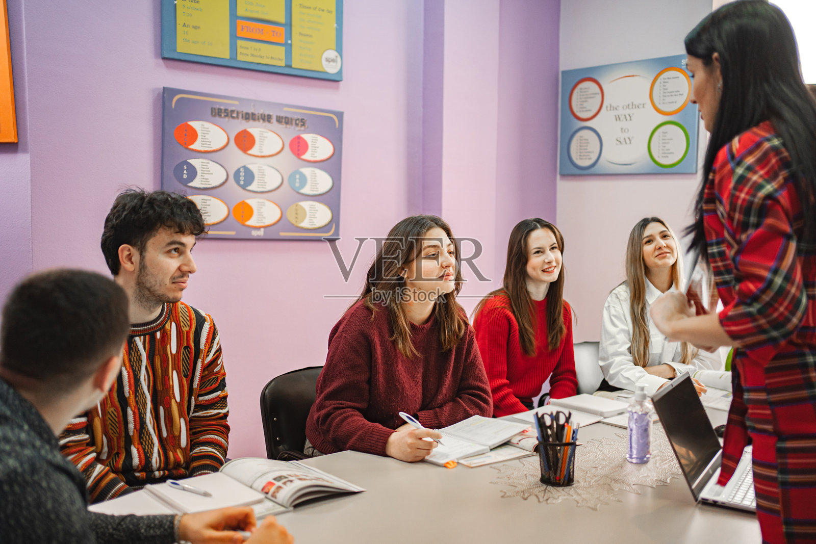 女教师在语言学校给十几岁的学生讲解科目照片摄影图片