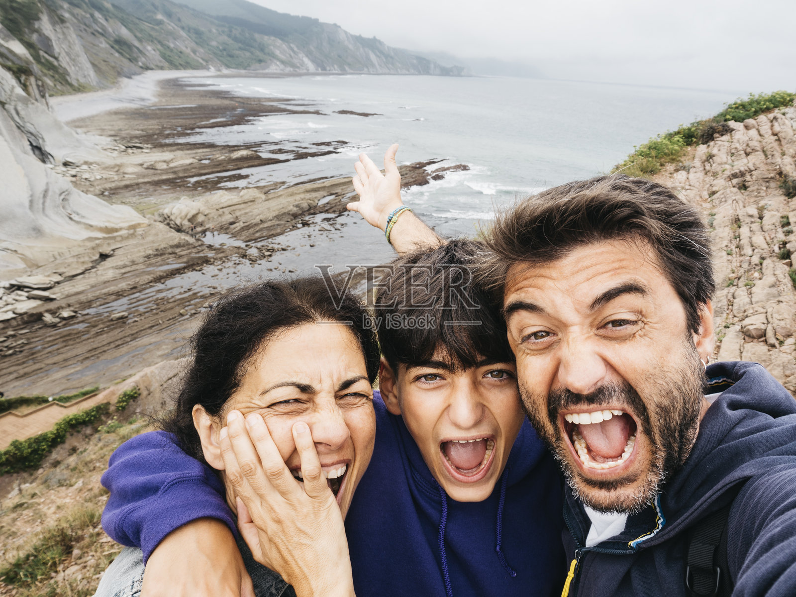 欢乐的一家人在悬崖上自拍。照片摄影图片