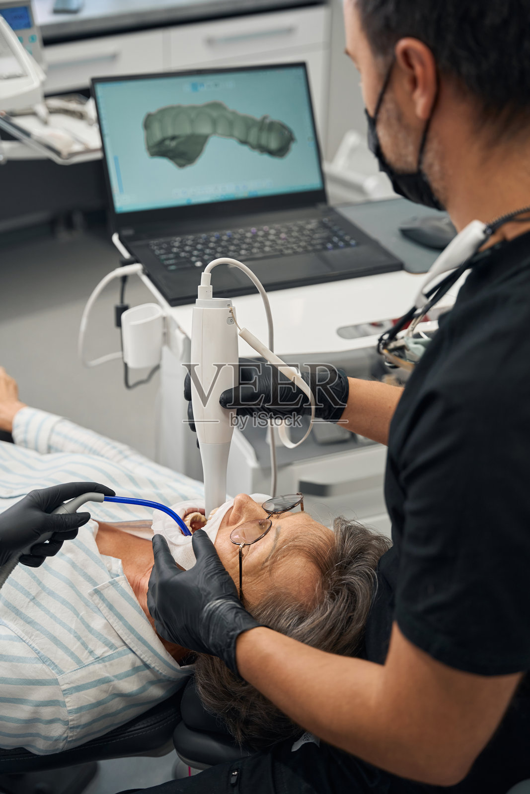 男牙医为老妇人治疗牙齿照片摄影图片