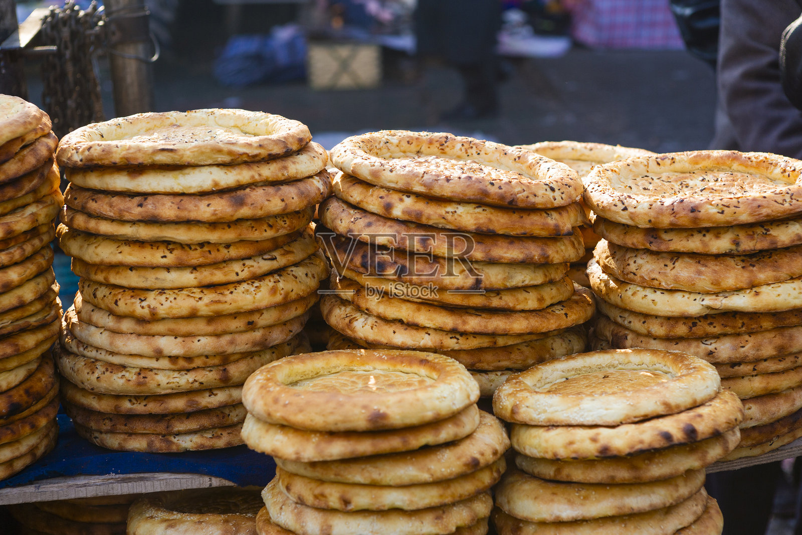 露天街市上,馕饼堆在桌子上照片摄影图片