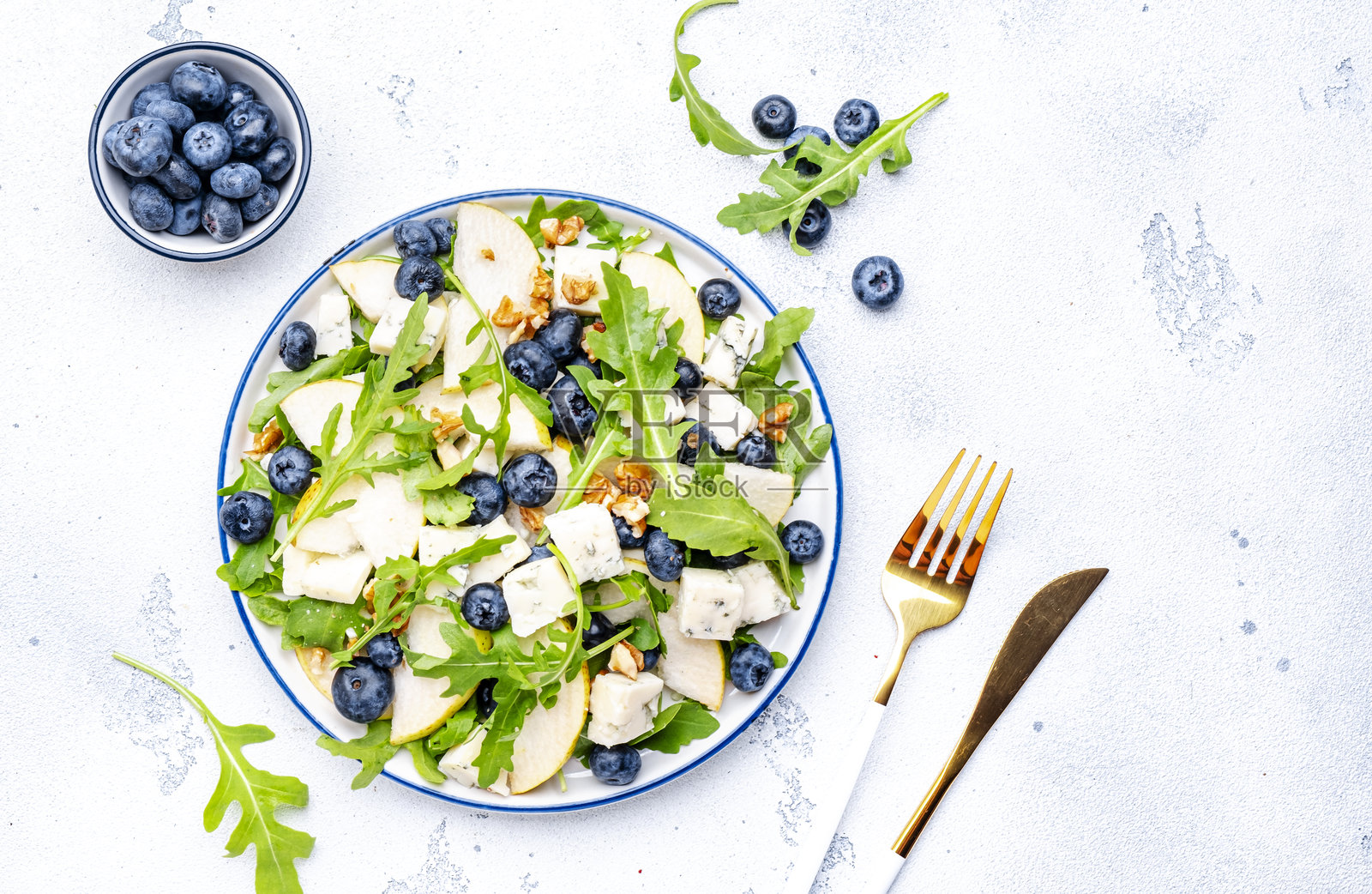 配梨,蓝莓,戈尔根佐拉奶酪,芝麻菜和核桃的美味沙拉。白色背景,俯视图照片摄影图片