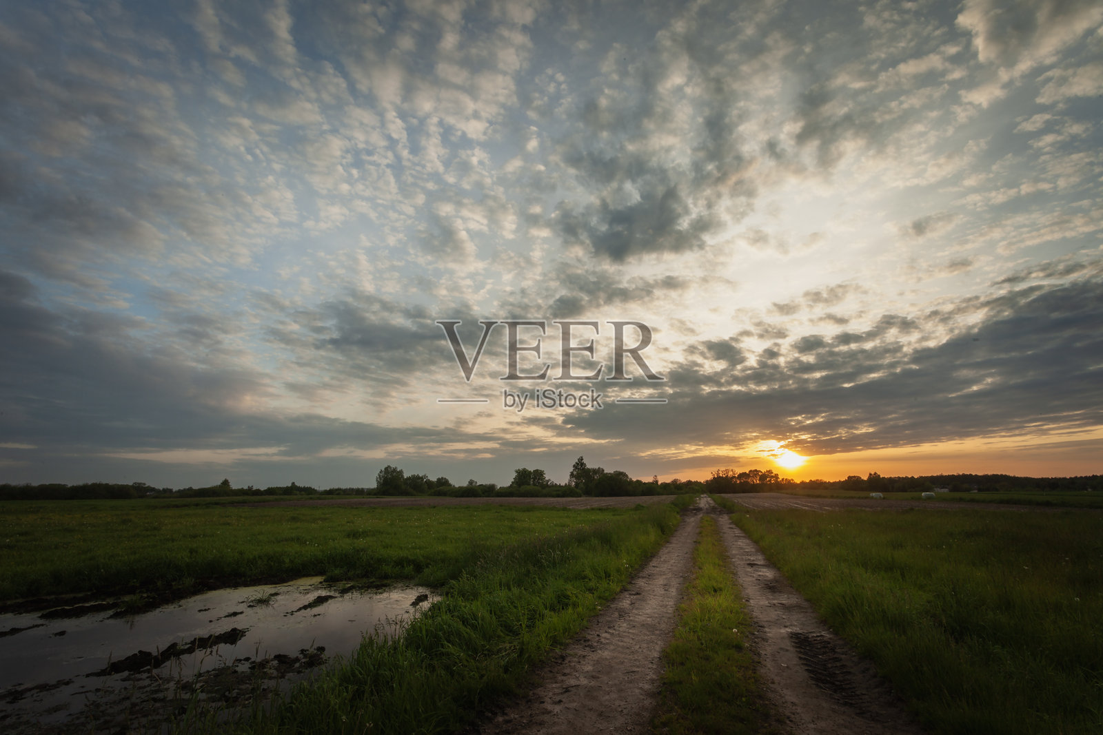 土路上乌云密布的日落照片摄影图片