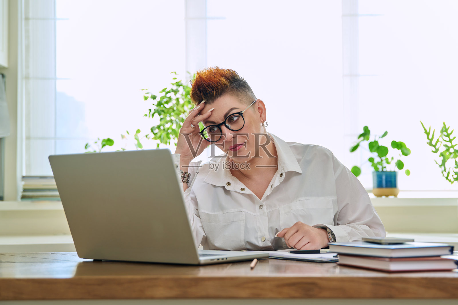 成熟的女性在家里用笔记本电脑工作的肖像照片摄影图片