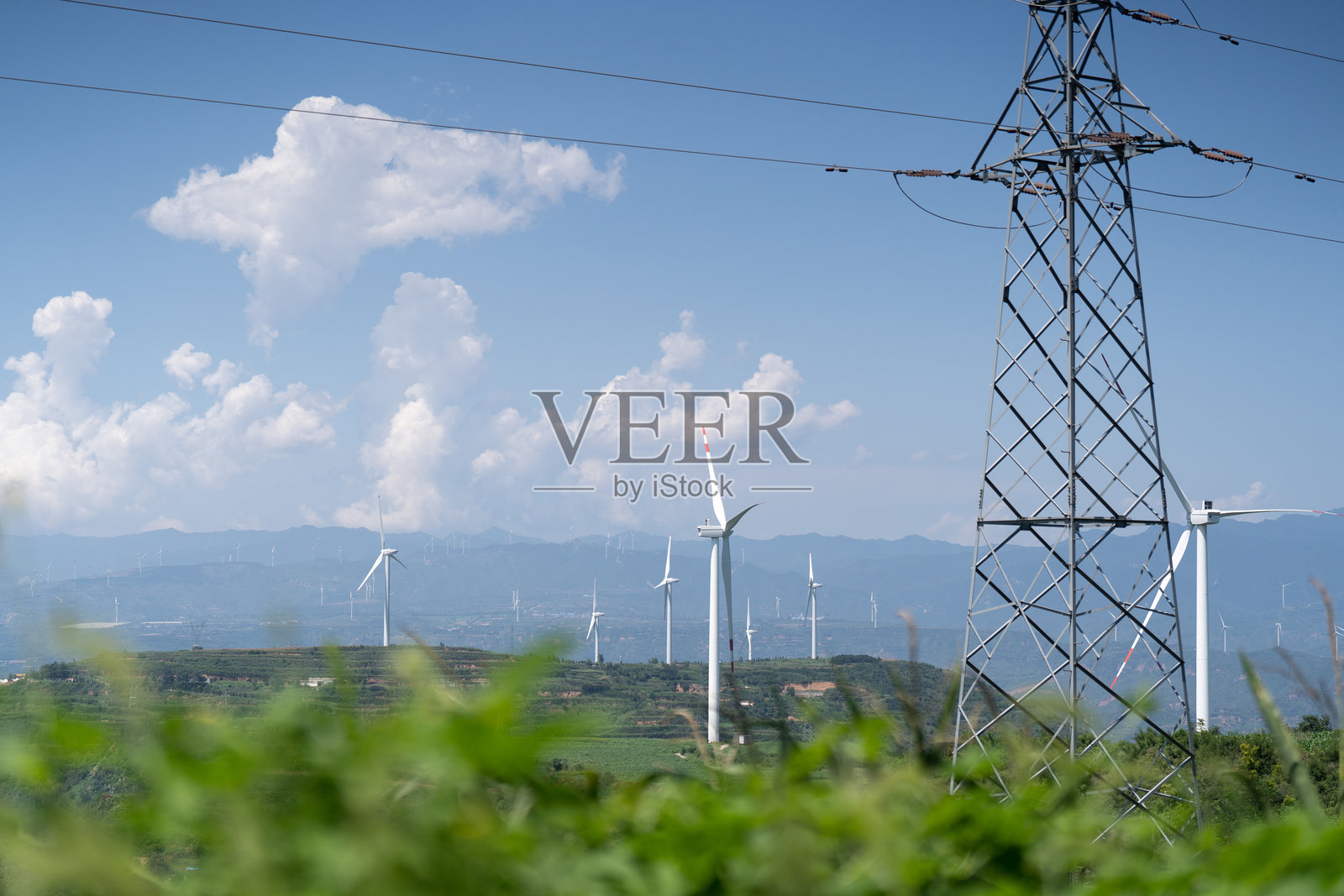 山上的风力发电场和特高压输电铁塔照片摄影图片
