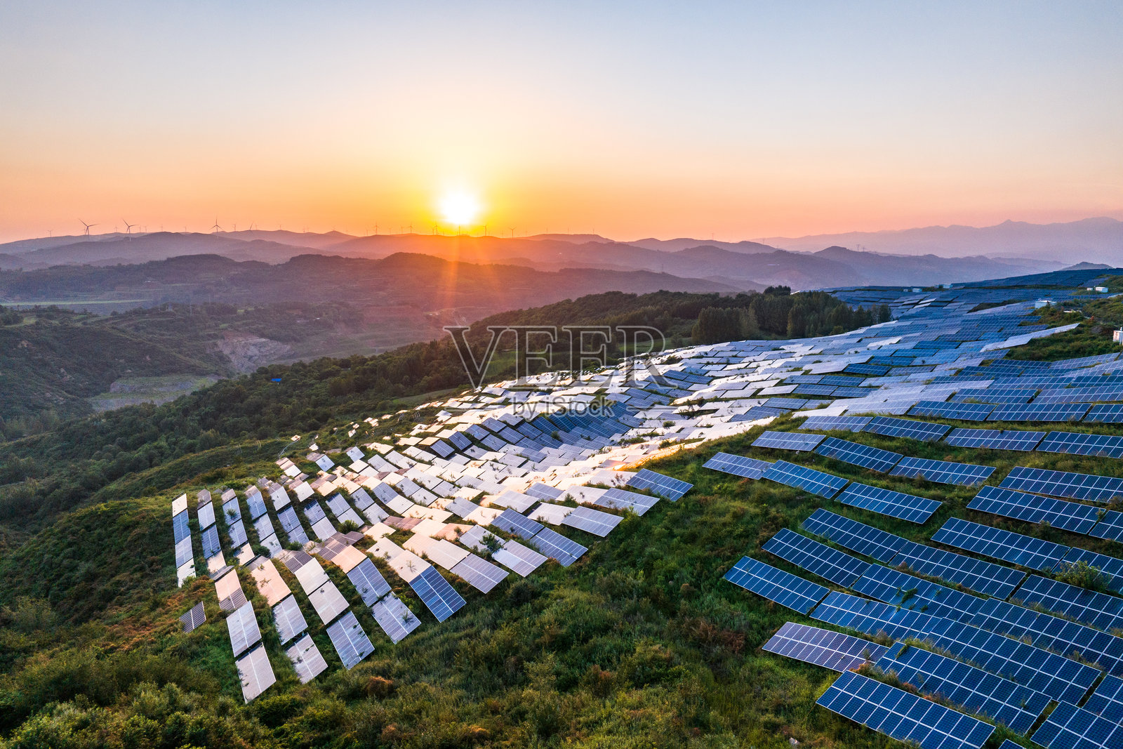 航拍山坡上光伏太阳能发电站照片摄影图片