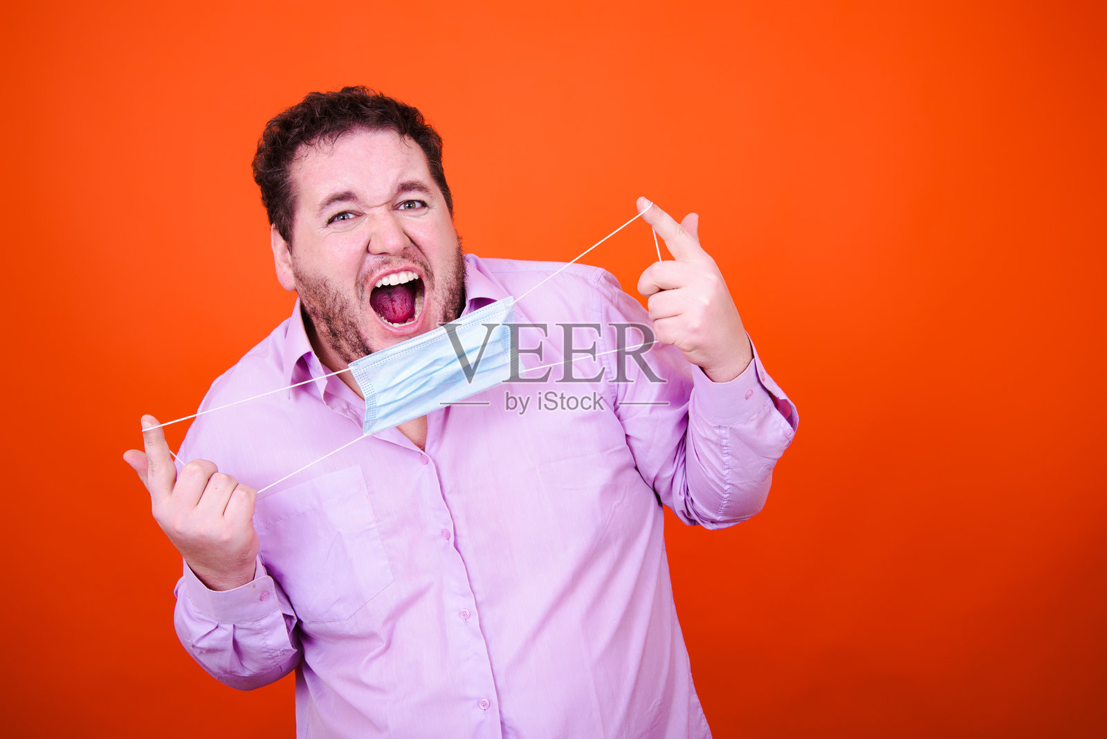 喜悦和乐趣:在橙色背景工作室跳舞的有趣醉酒成年男人照片摄影图片