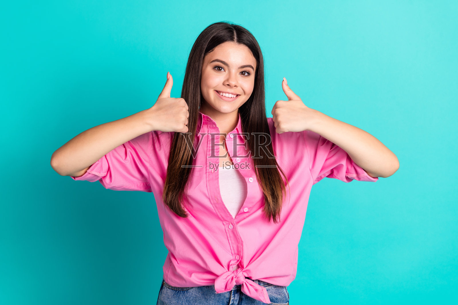 照片肖像可爱的少女女士拇指向上批准穿着时尚的粉红色服装孤立的青色背景照片摄影图片