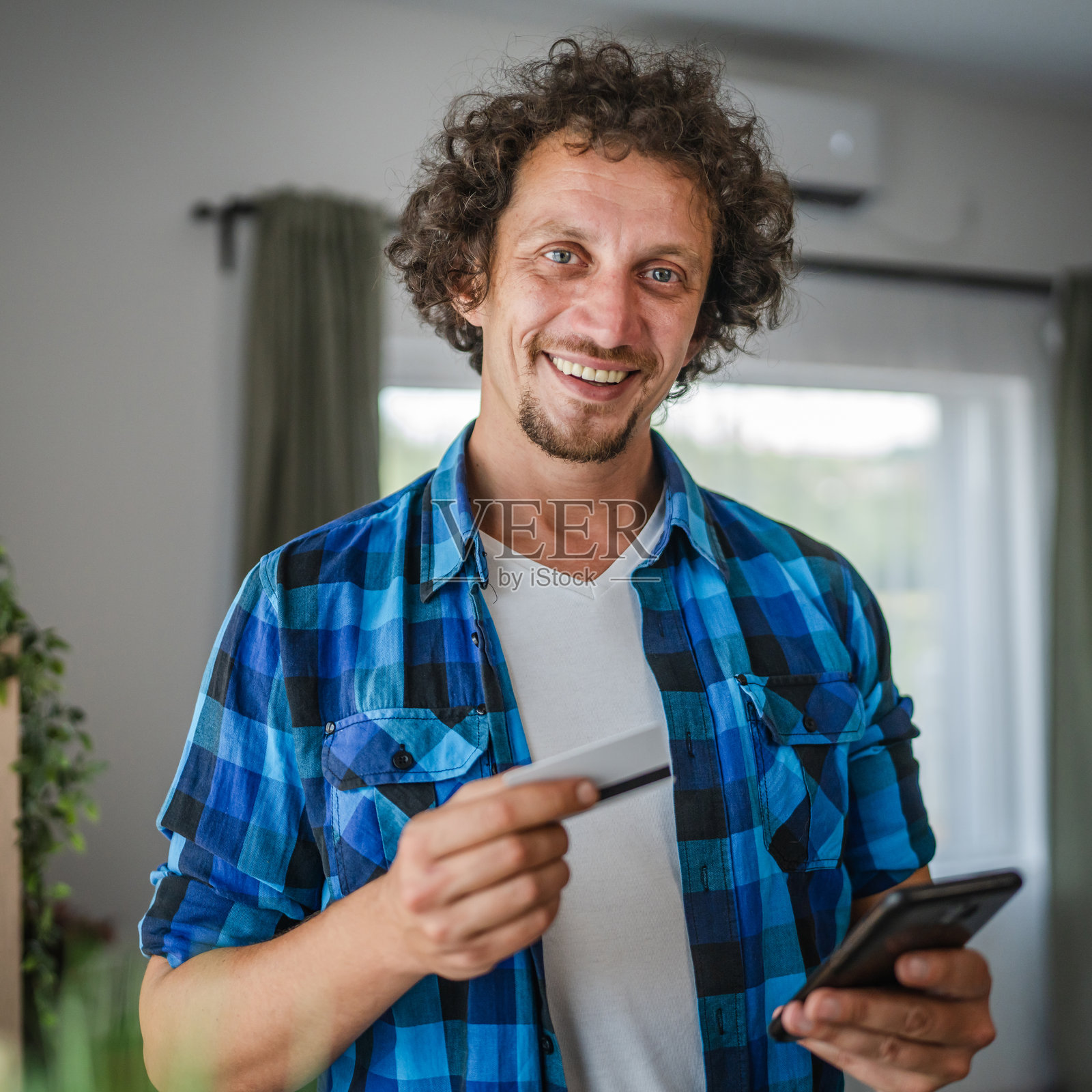 画像中的男子用信用卡在手机上网购照片摄影图片