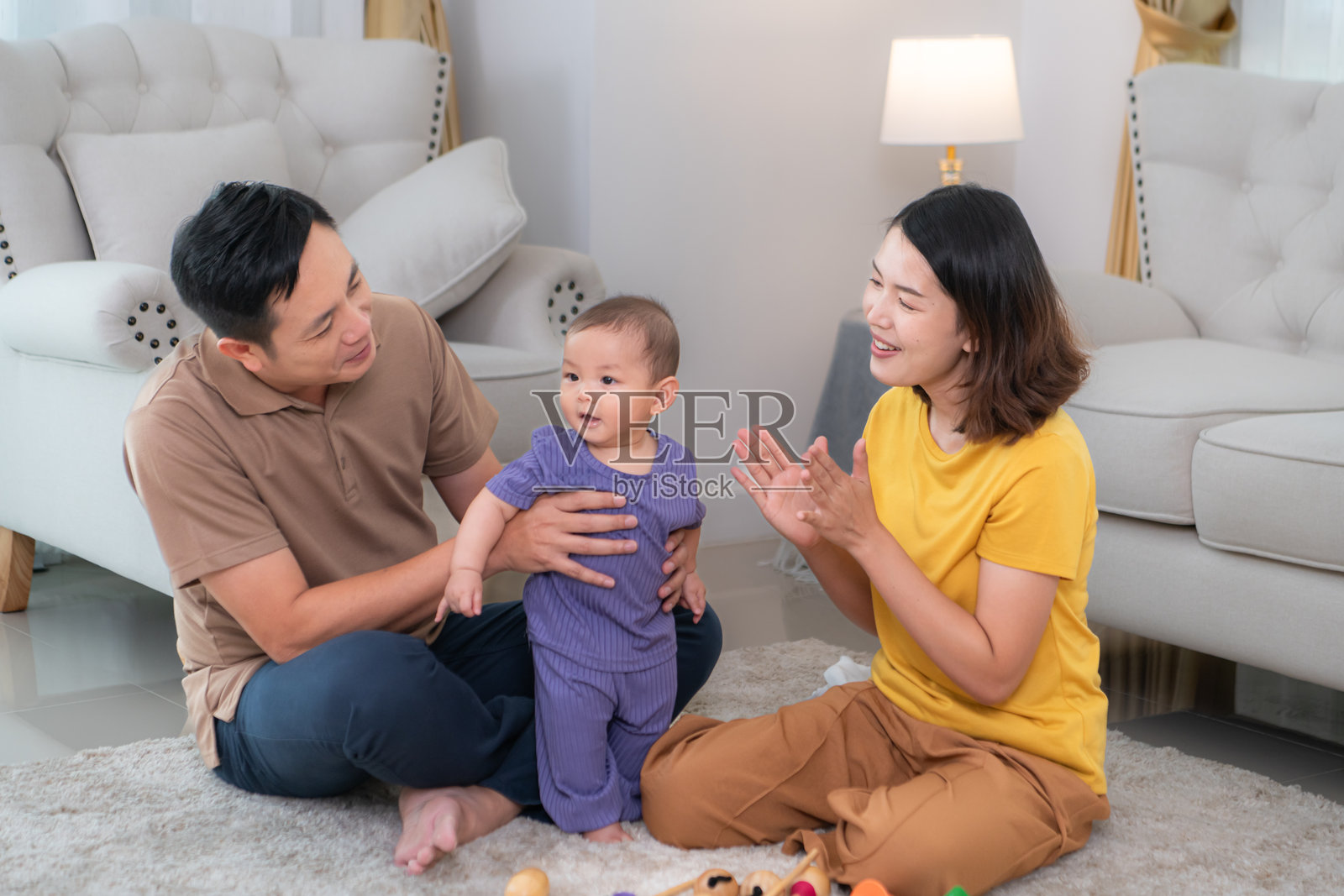 父母和他们的小孩在房子的客厅里快乐地玩耍照片摄影图片