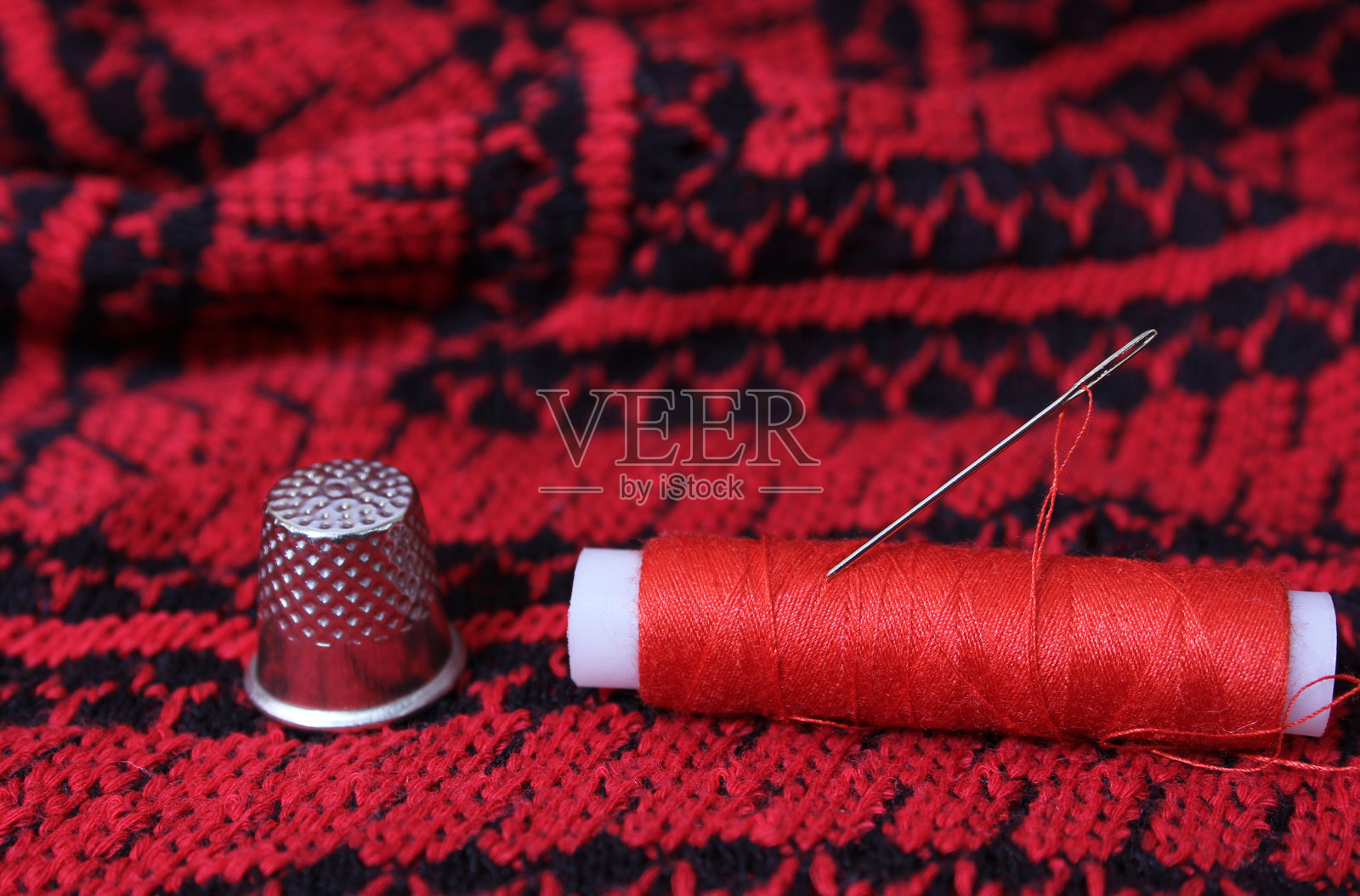 红色和黑色织物与线和剪刀照片摄影图片