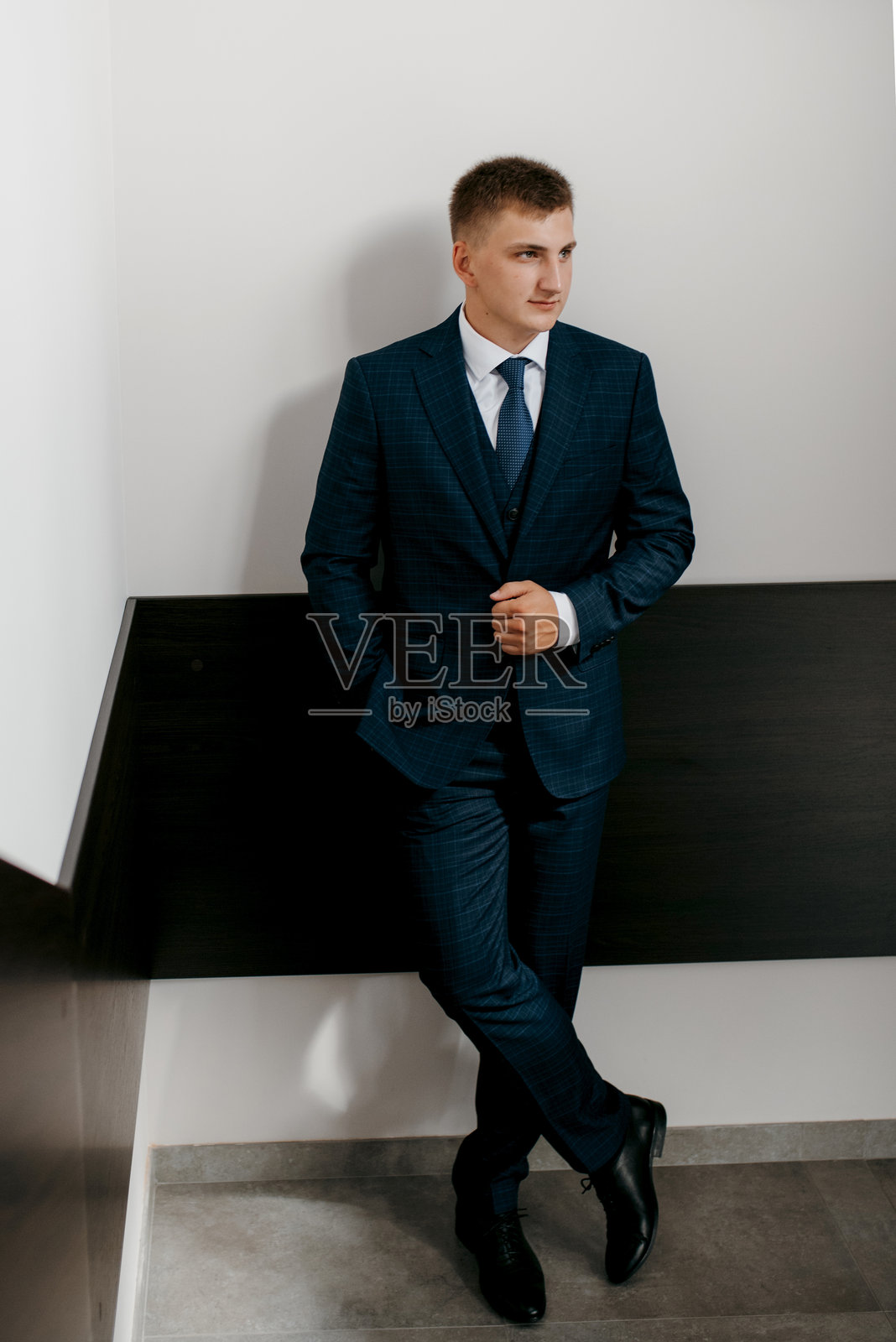 婚礼当天新郎身穿蓝色三件套西装打着领带的照片照片摄影图片