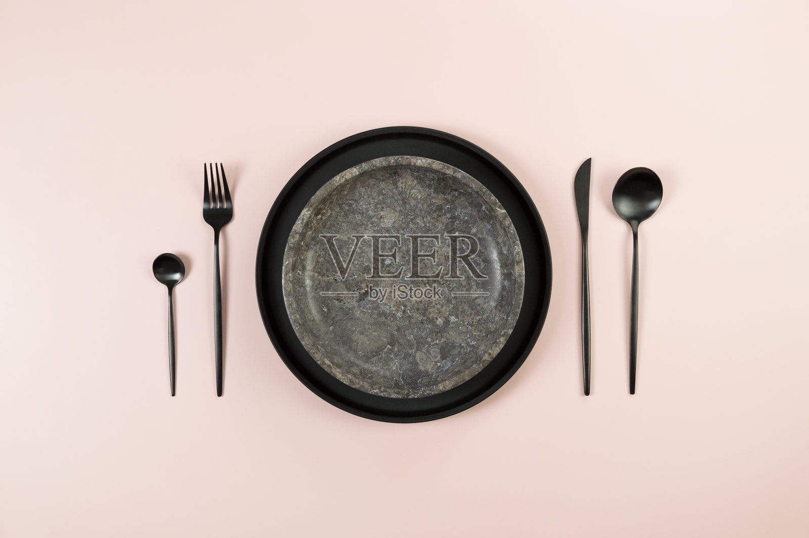俯视图棕色大理石盘子,黑色盘子和餐具在粉红色的背景。食物摆放,石盘。照片摄影图片