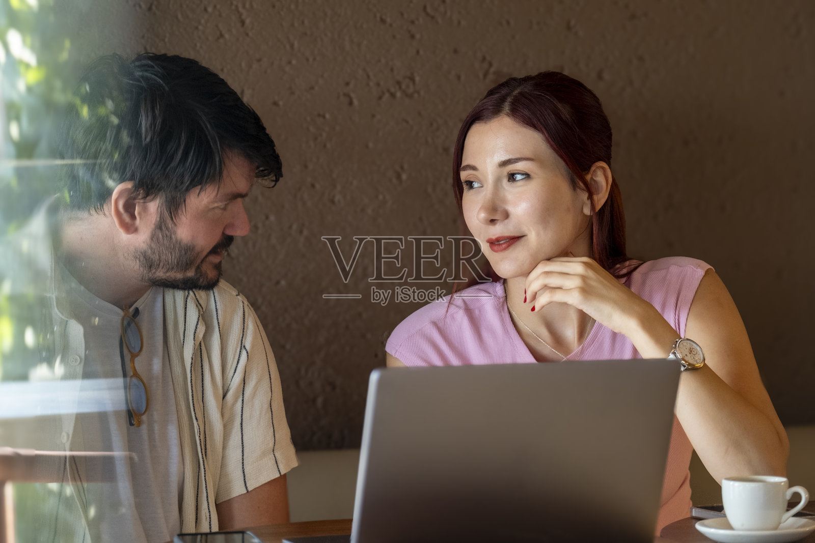 夏日里,一男一女都是商务人士,他们正在办公室外的咖啡馆里愉快地用笔记本电脑工作照片摄影图片