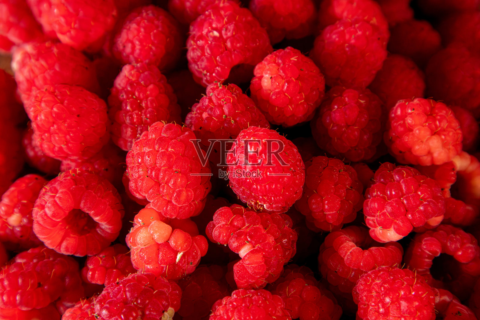 桌上有各种各样的覆盆子。覆盆子是可食用的,有酸甜两种口味。它们还富含维生素C,对身体有益。照片摄影图片