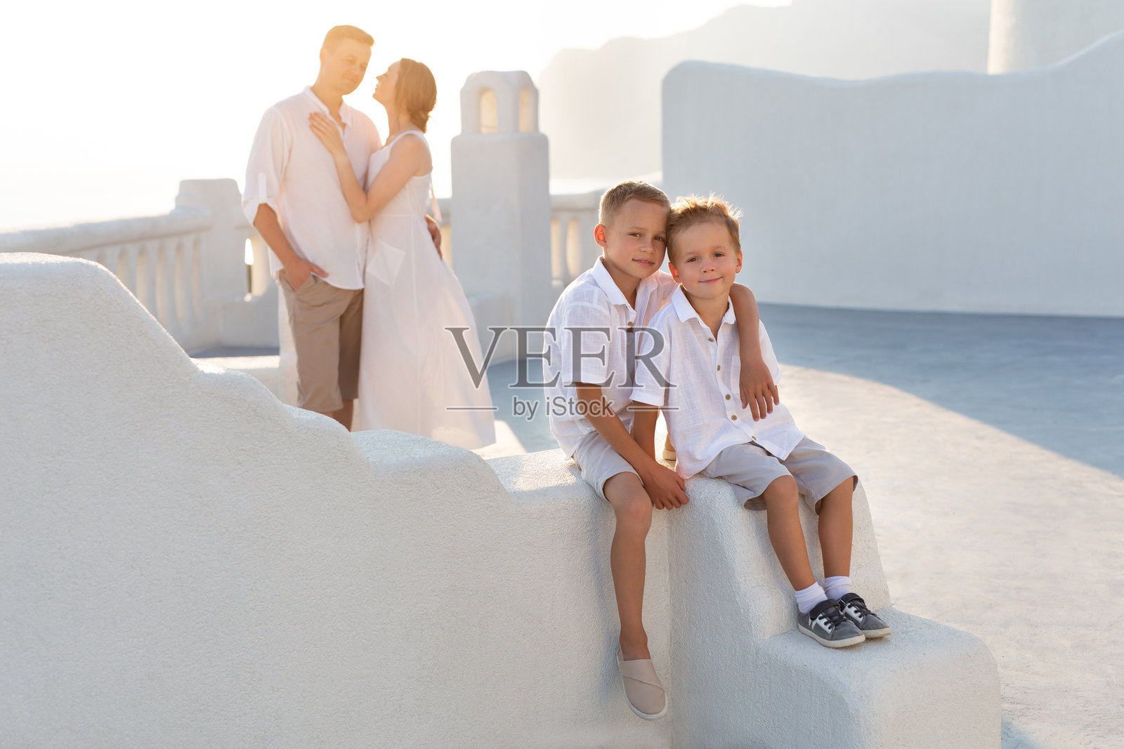 一家人带着孩子在希腊圣托里尼岛度假。照片摄影图片