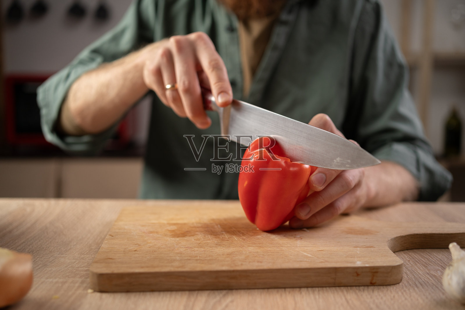 拿着大刀切甜椒的人。家庭烹饪照片摄影图片