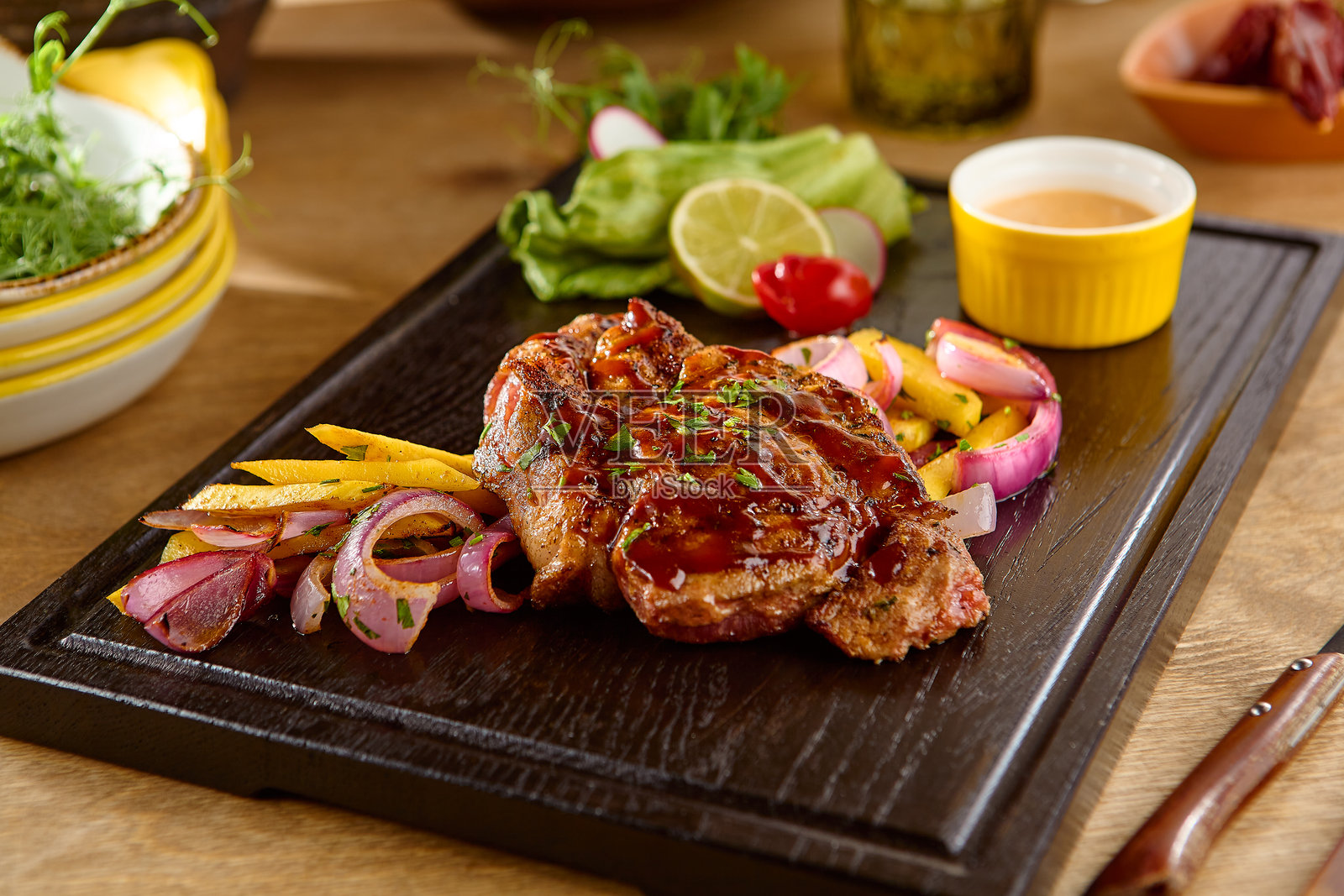 烧烤猪肉配洋葱和胡椒,木质拼盘,充满活力和多汁照片摄影图片