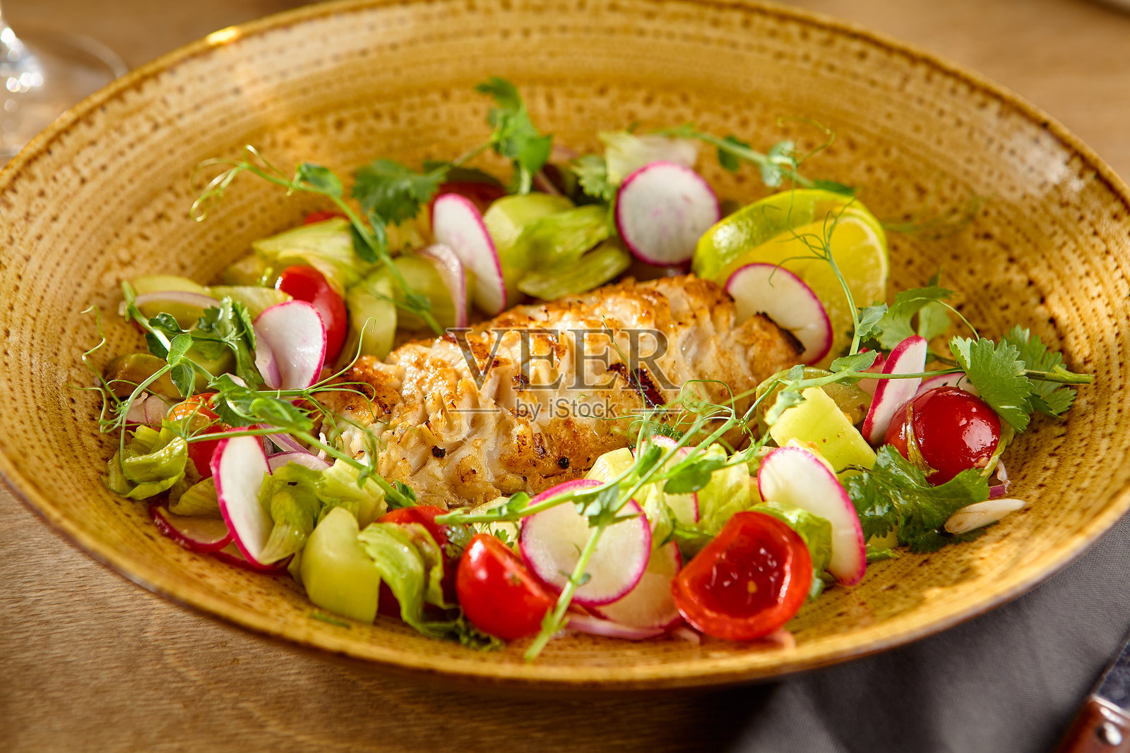 美味派克鲈鱼天妇罗与新鲜蔬菜沙拉在质朴的陶瓷盘子照片摄影图片