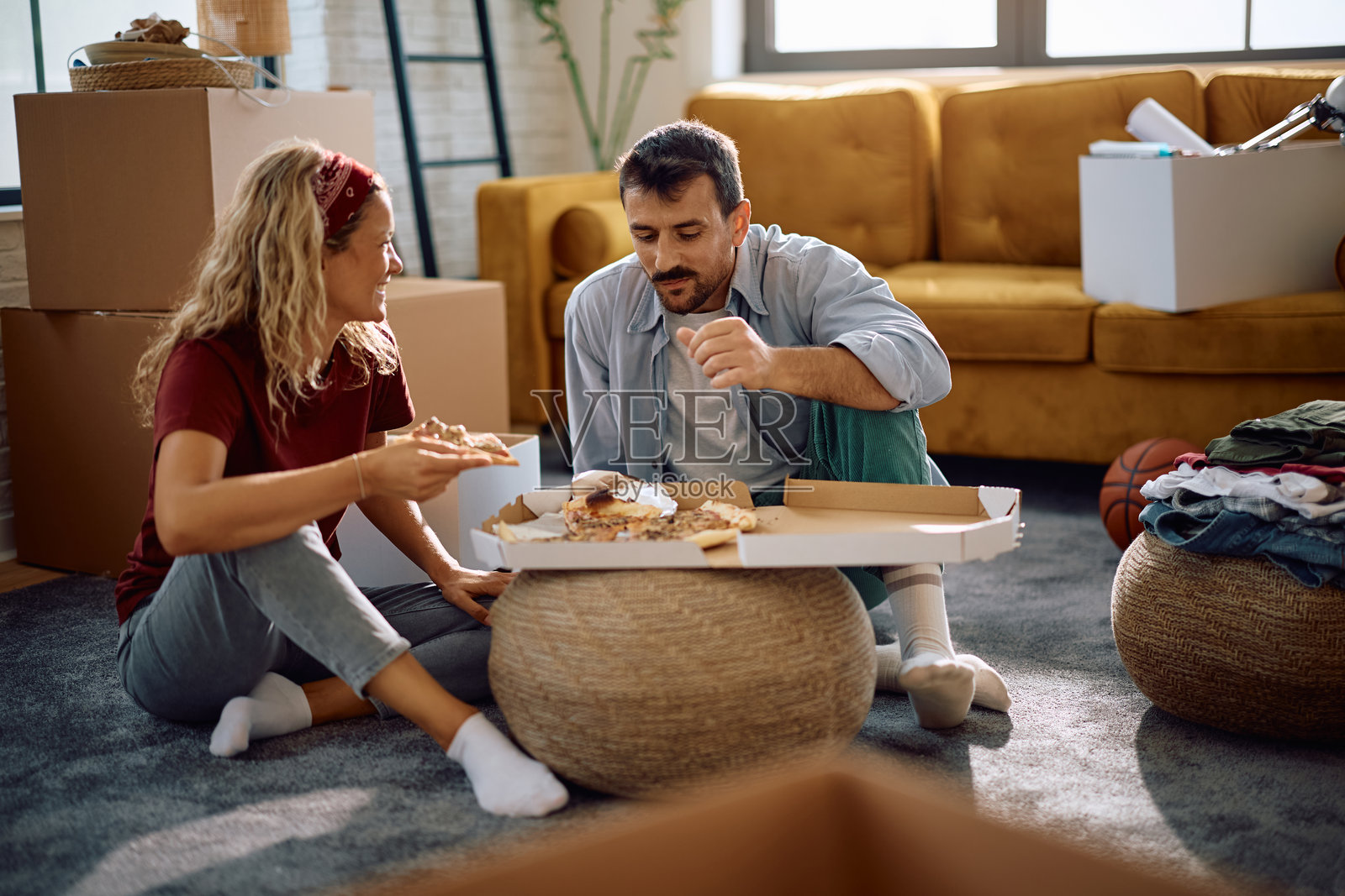 幸福的夫妇在搬进新家后午餐吃披萨。照片摄影图片