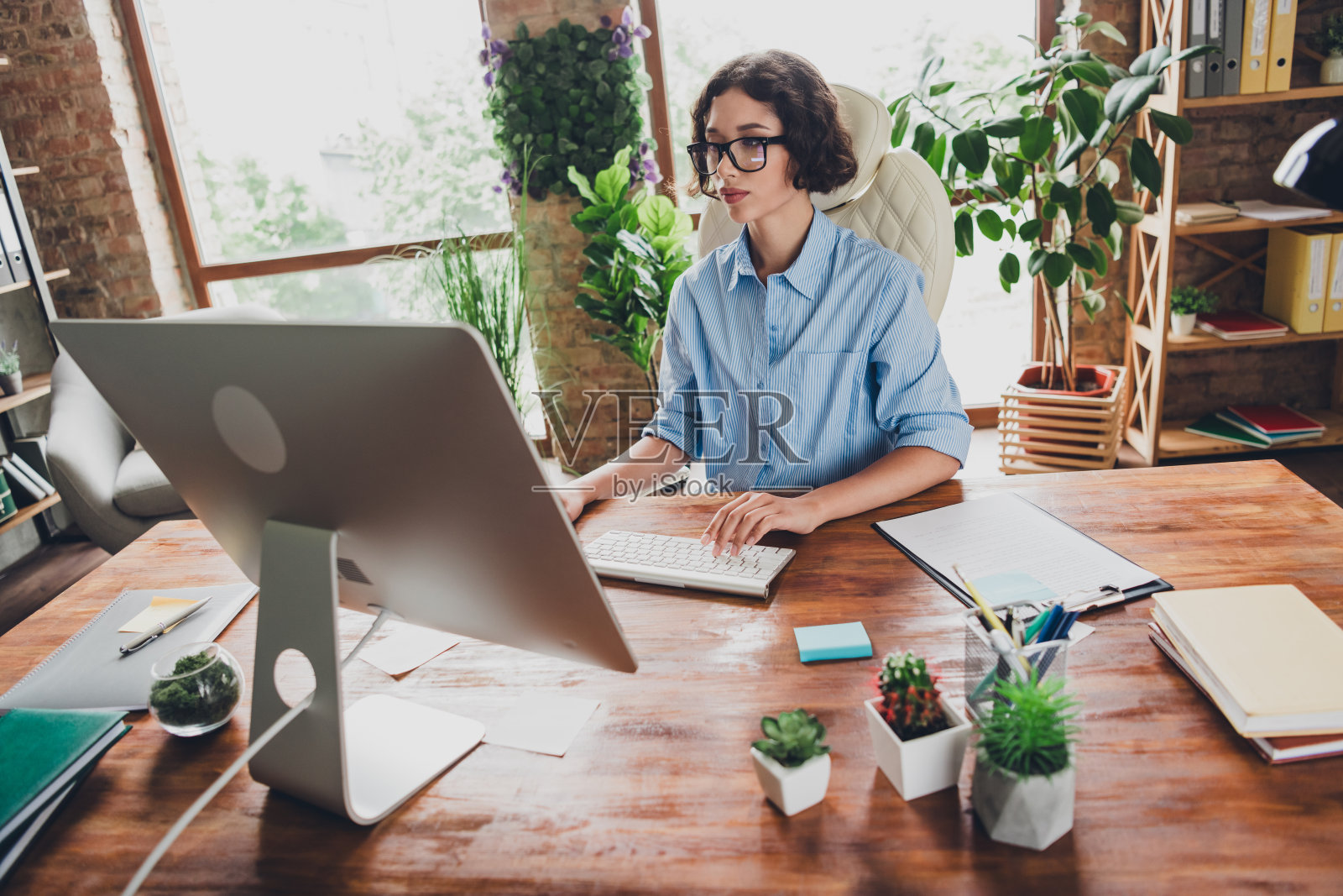 快乐忙碌的女士招聘人员的照片穿着衬衫,眼镜工作的现代设备在室内工作的工作站阁楼照片摄影图片