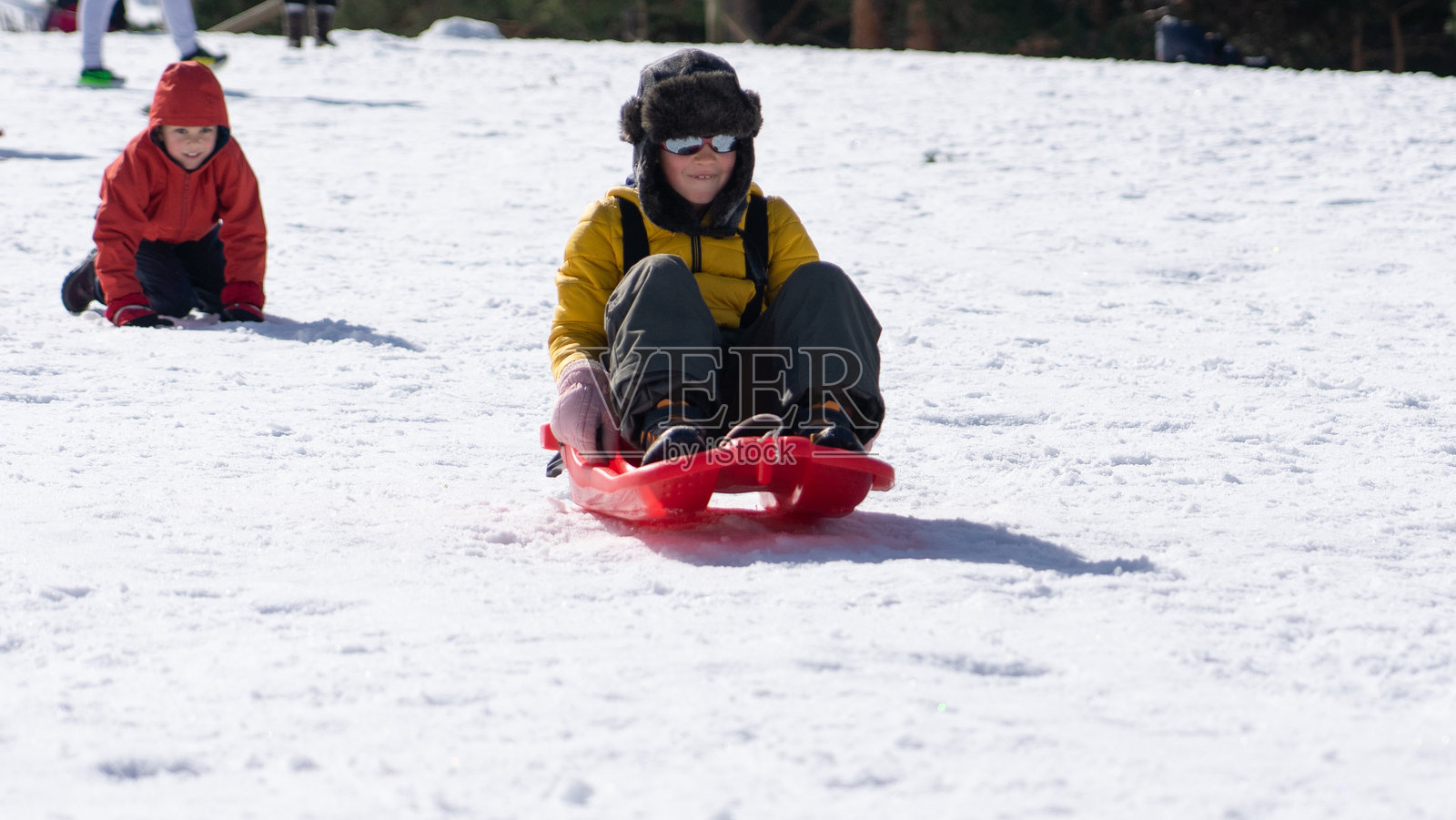 孩子们在雪地里玩雪橇照片摄影图片