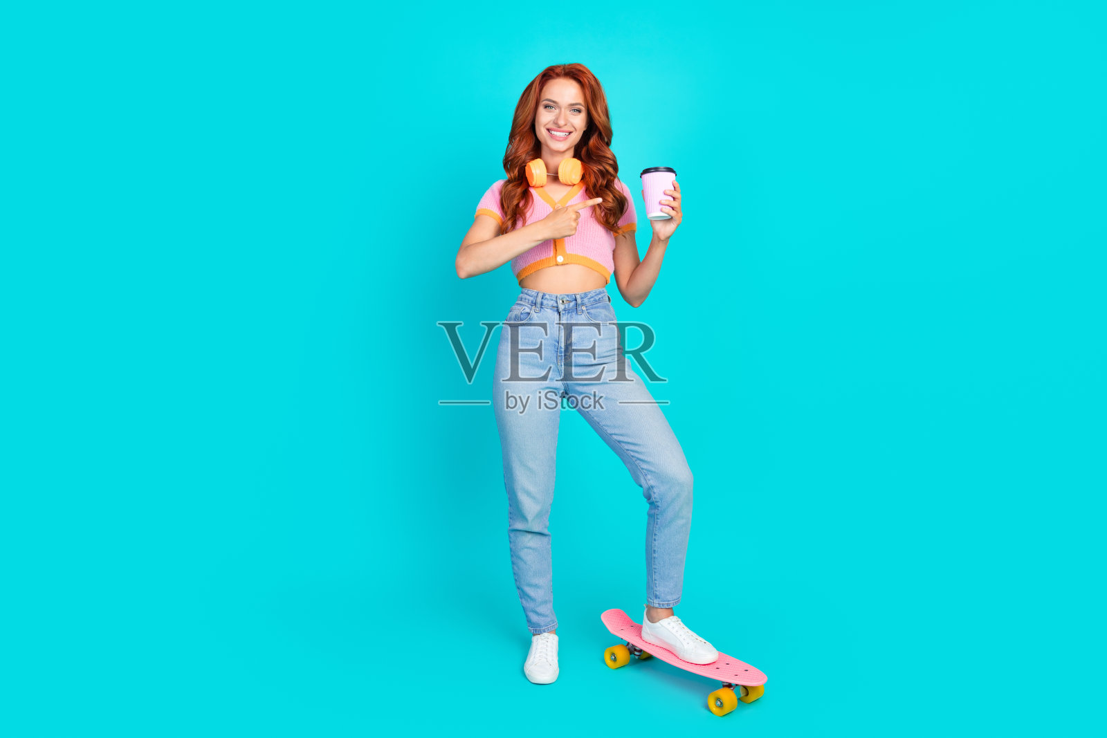 迷人的年轻女子的全身照片点喝咖啡pennboard穿着时尚的粉红色衣服孤立在青色背景照片摄影图片