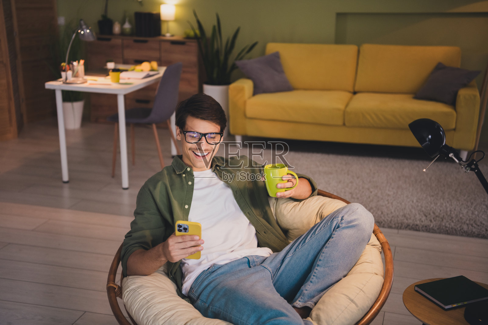 有魅力的男人穿着卡其色的衣服,坐在柔软的椅子舒适的周末晚上室内公寓室内照片摄影图片