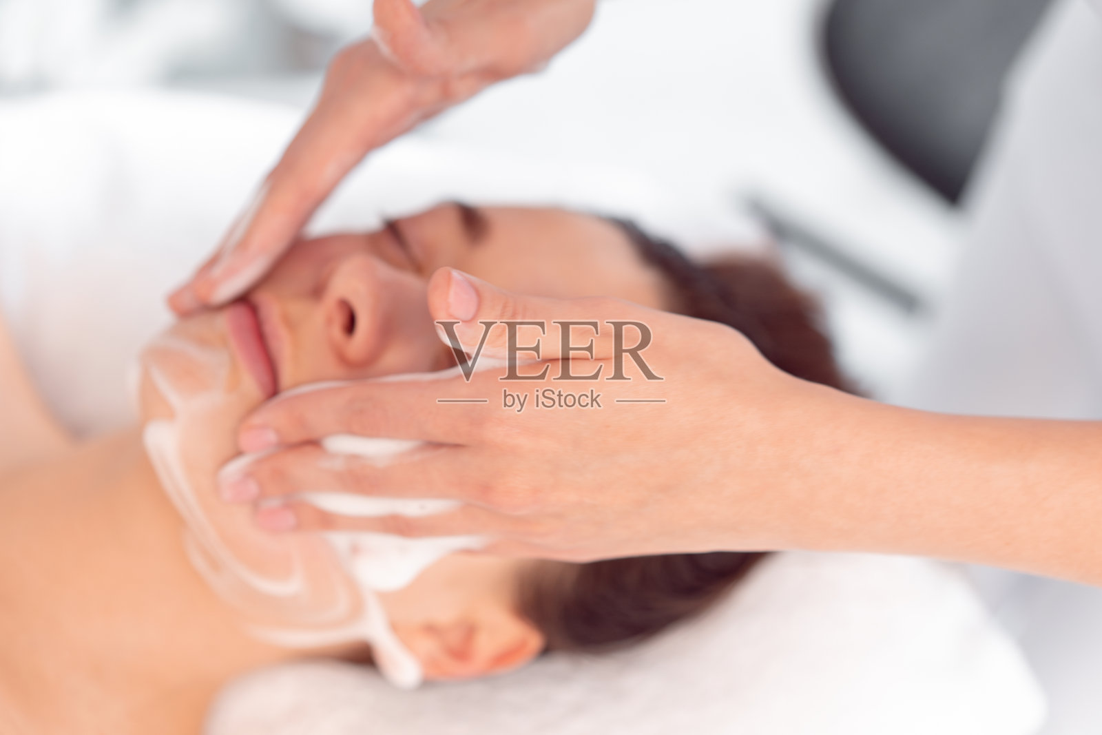 农作物匿名美容师按摩妇女的脸在美容院照片摄影图片