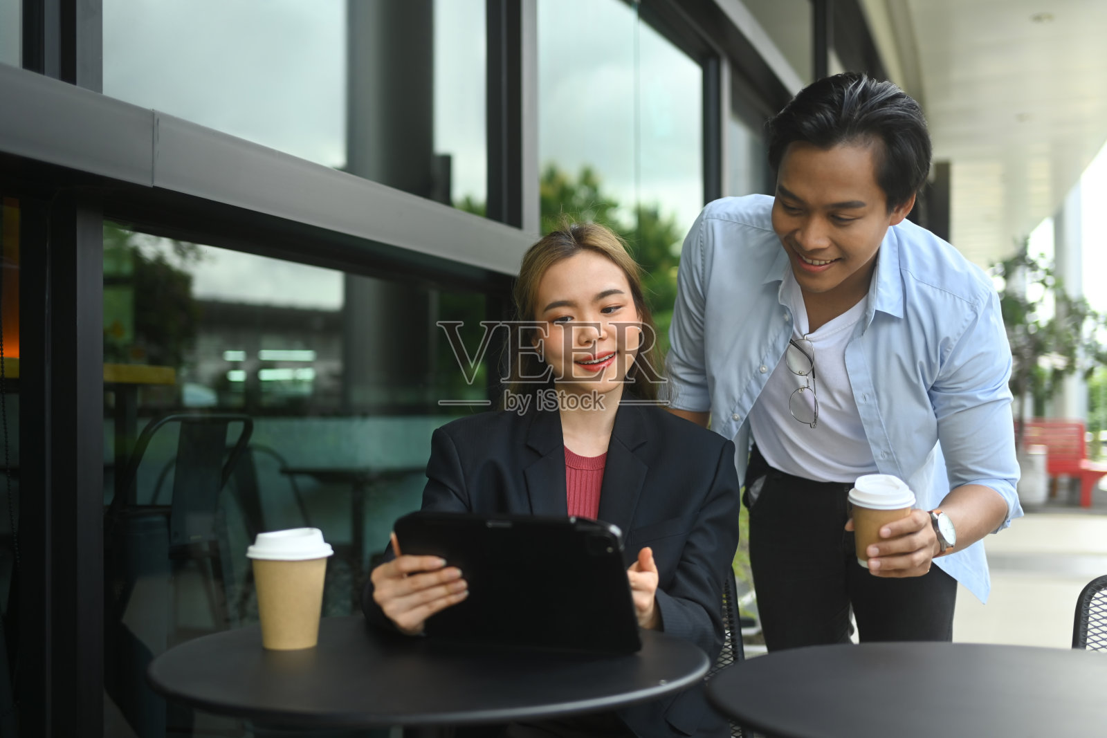 年轻的商业同事在户外咖啡馆讨论项目成果照片摄影图片