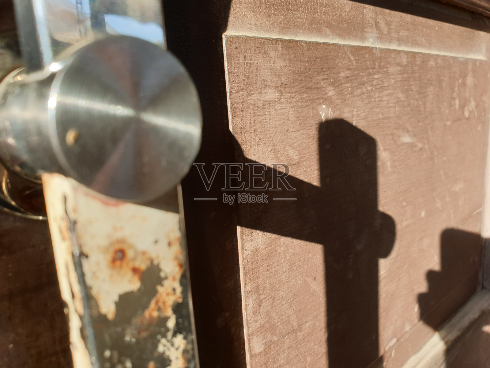 质地为棕色的木门,有门把手的影子照片摄影图片