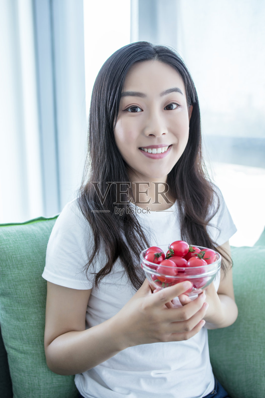 一个女人在室内吃西红柿樱桃沙拉的特写照片摄影图片