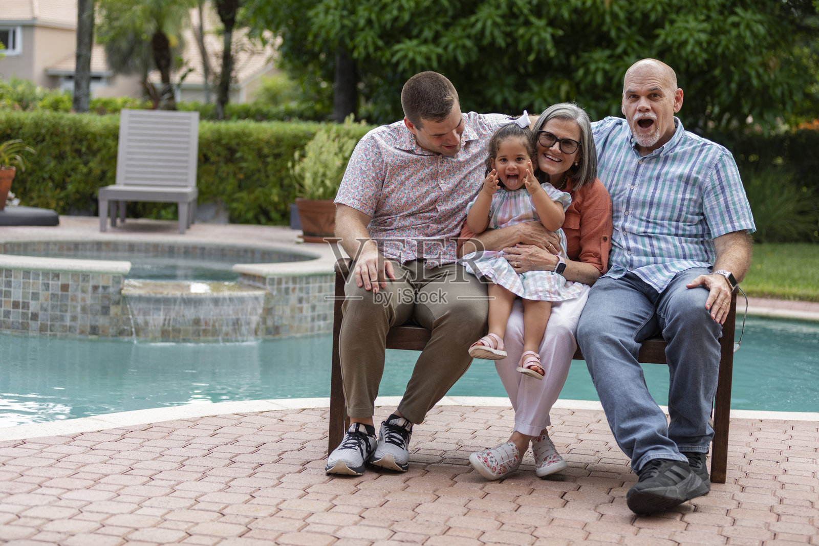 爷爷奶奶和刚成年的儿子、孙女坐在木凳上。照片摄影图片