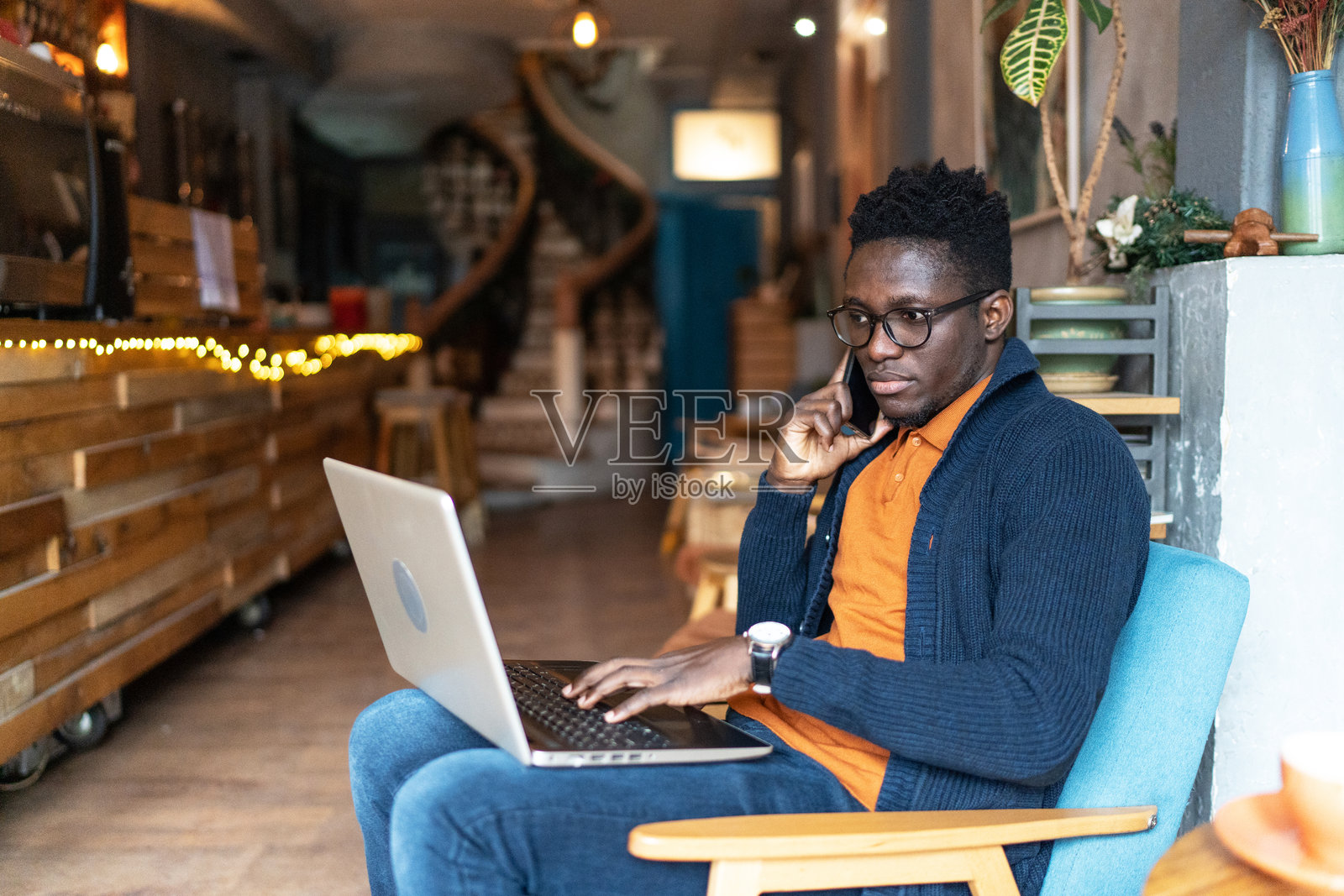 帅气的男学生在咖啡店用他的笔记本电脑照片摄影图片
