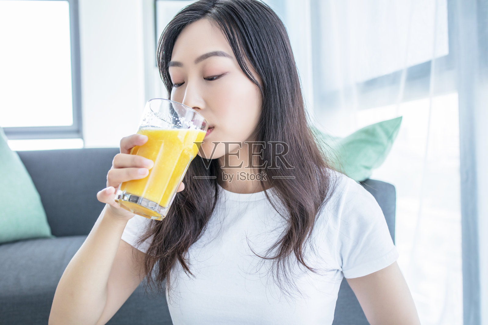 快乐的年轻女子捧着多汁的橙子在她眼前。健康饮食理念。饮食。孤立在白色之上。照片摄影图片