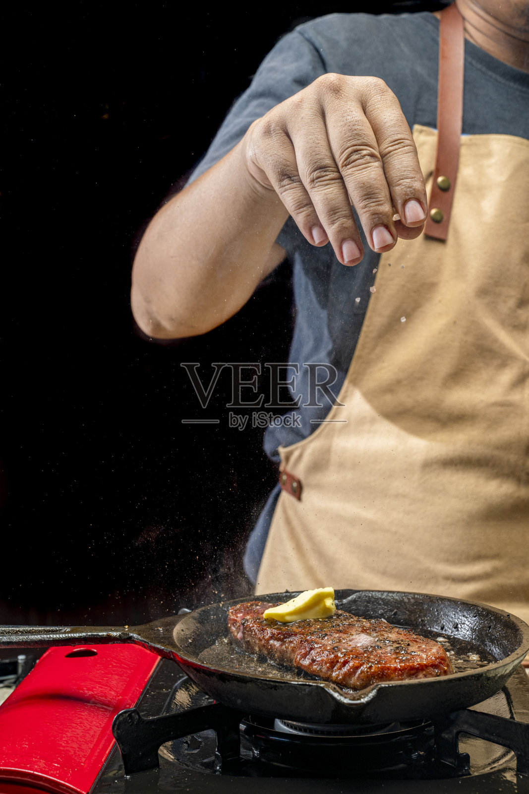 一名男子正在往里脊肉上撒盐照片摄影图片