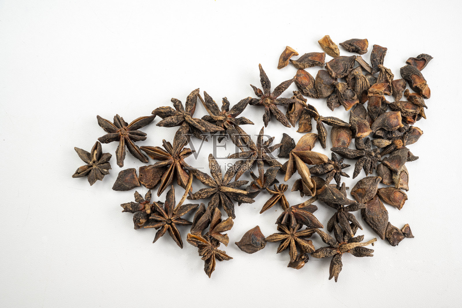 一束晒干的八角茴香种子铺在白色的表面上照片摄影图片