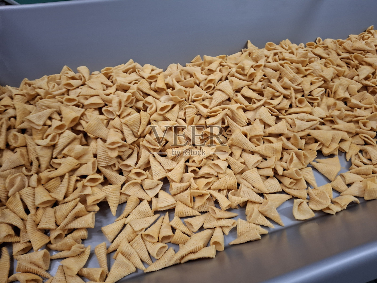 不锈钢容器里的零食,输送零食产品包装的不锈钢桶,生产零食的工厂,工厂里生产的玉米片照片摄影图片