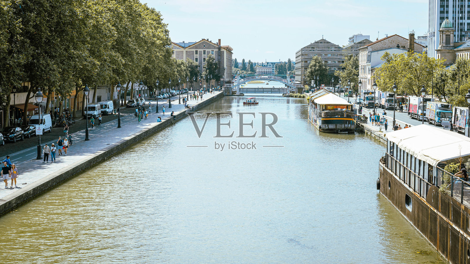 夏日里,法国巴黎的乌尔克运河。望向斯大林格勒rotonde,俯瞰升起桥和几艘船照片摄影图片