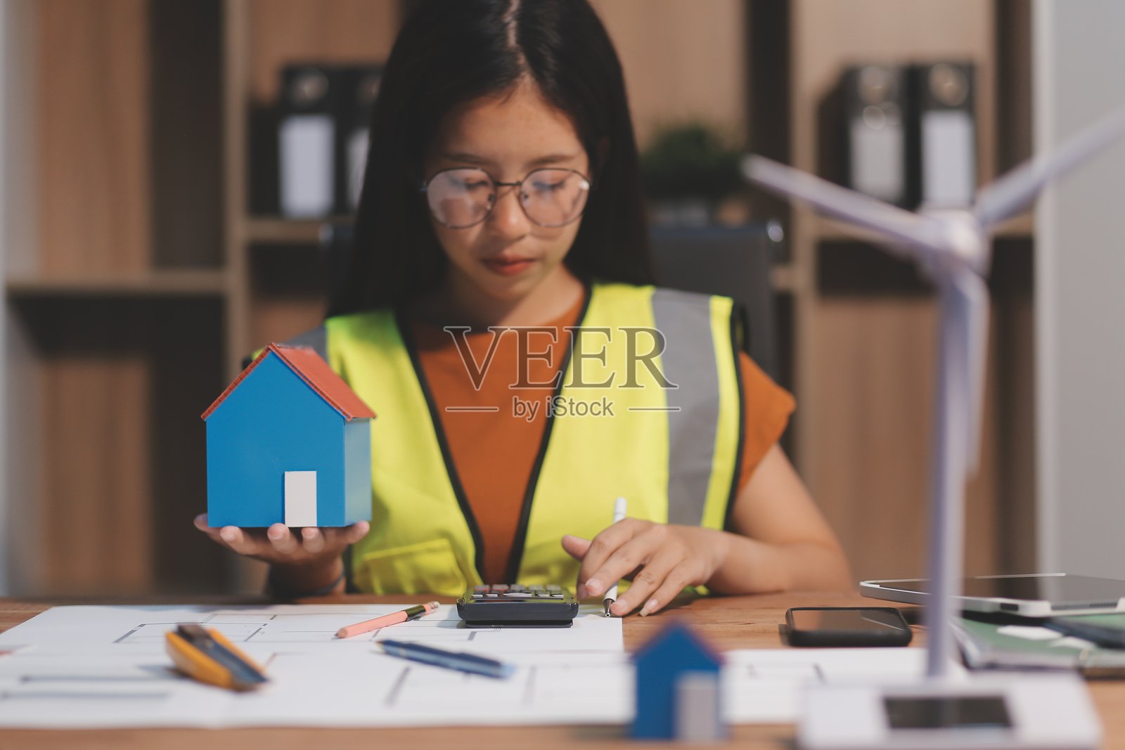 在家工作的女建筑师她看了看蓝图。照片摄影图片