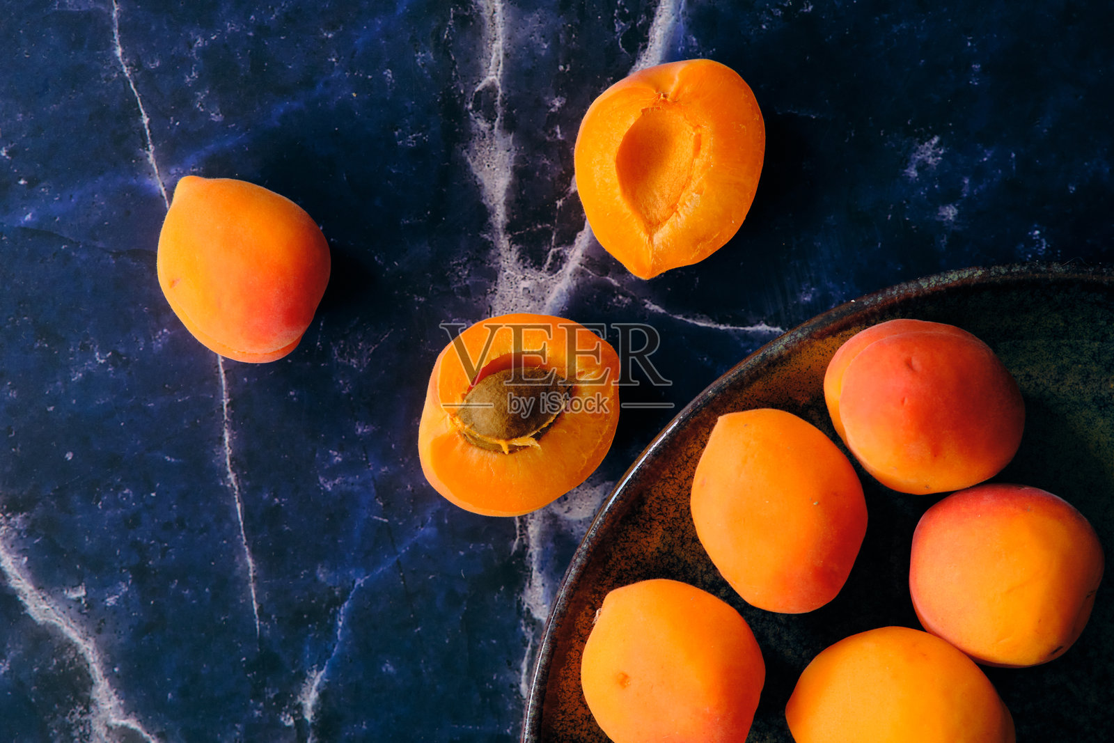 成熟的杏子放在黑色大理石上照片摄影图片