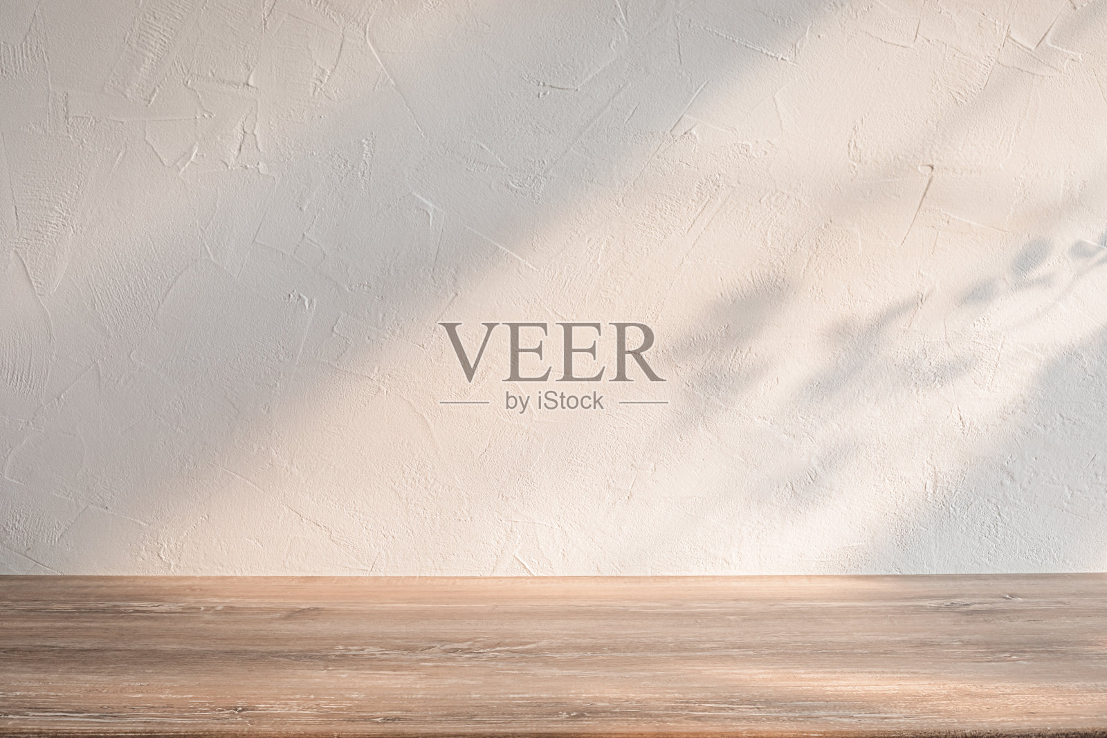 明亮的极简风格木桌,靠在有质感的浅色墙壁旁,柔和的阴影映衬在温馨明亮的室内空间中。照片摄影图片