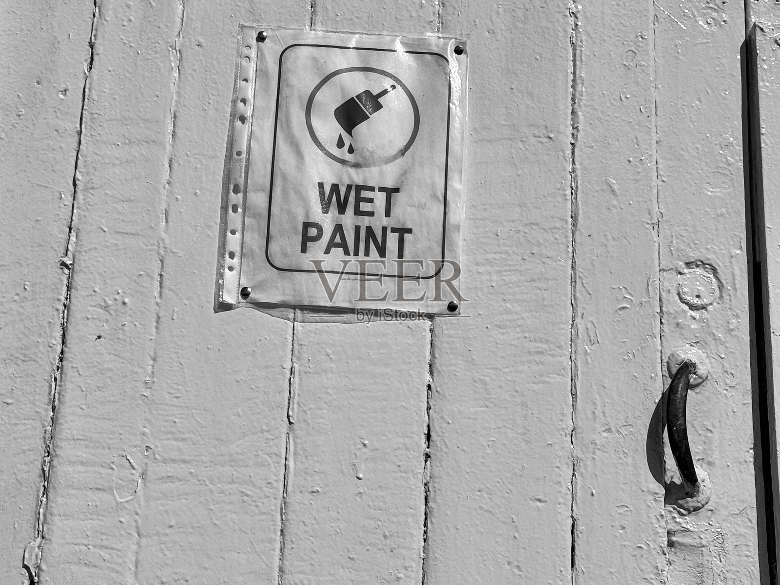 一块“湿漆”警告标志贴在木门上照片摄影图片