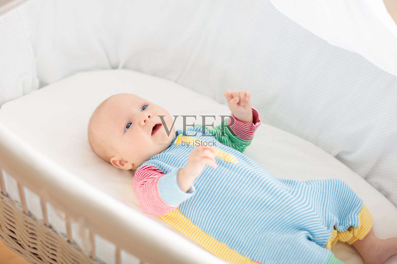 可爱的男婴在白色婴儿床里照片摄影图片