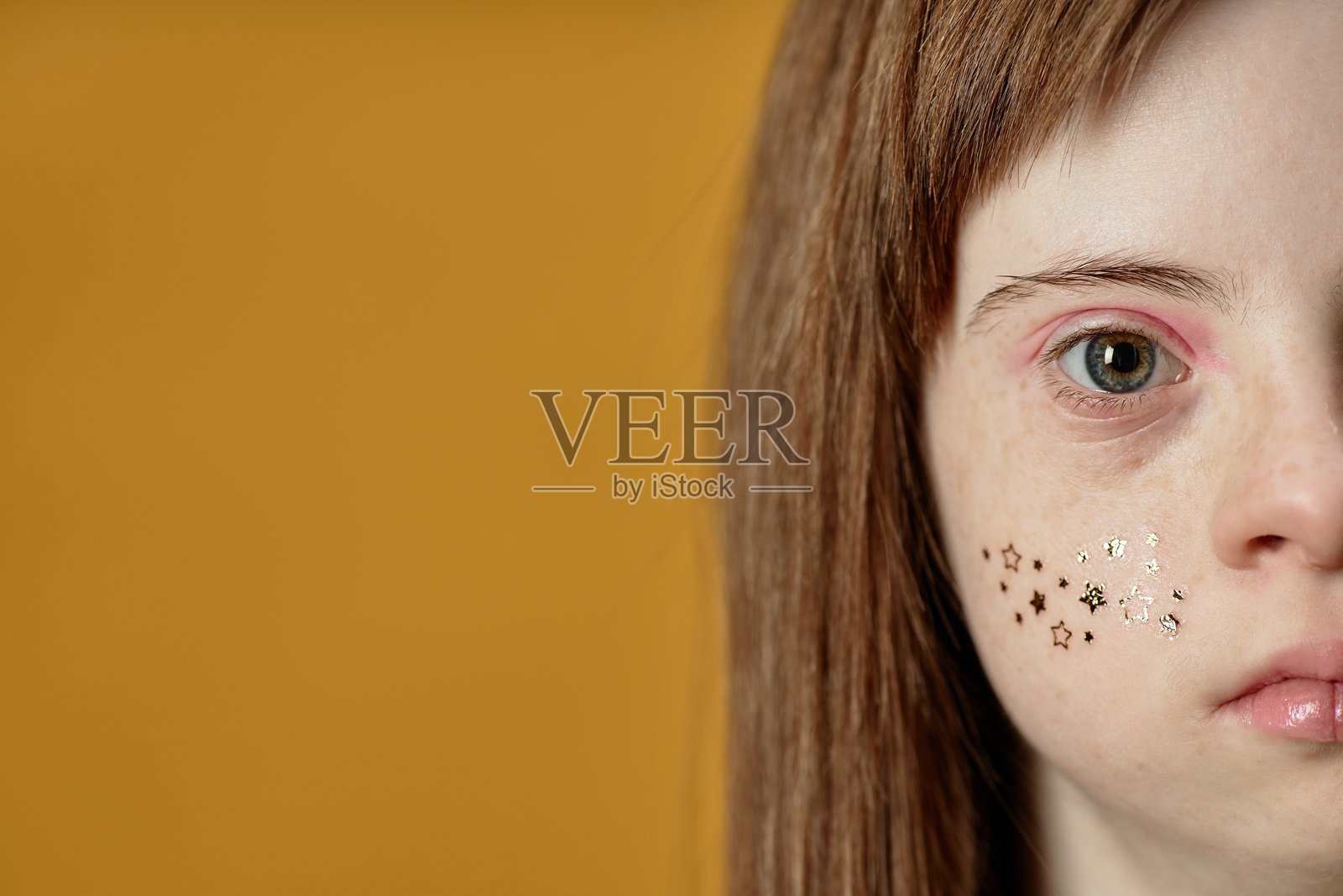 长发小孩的肖像,脸上有闪光粉照片摄影图片