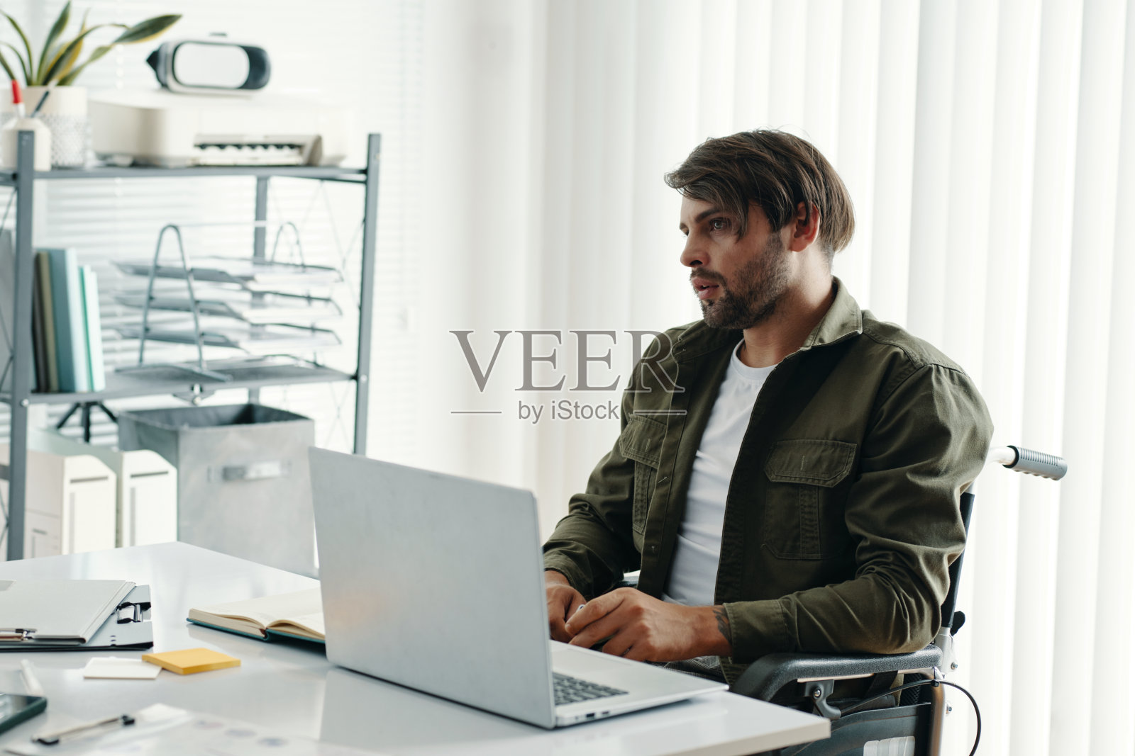 残疾商人在办公室使用笔记本电脑工作照片摄影图片