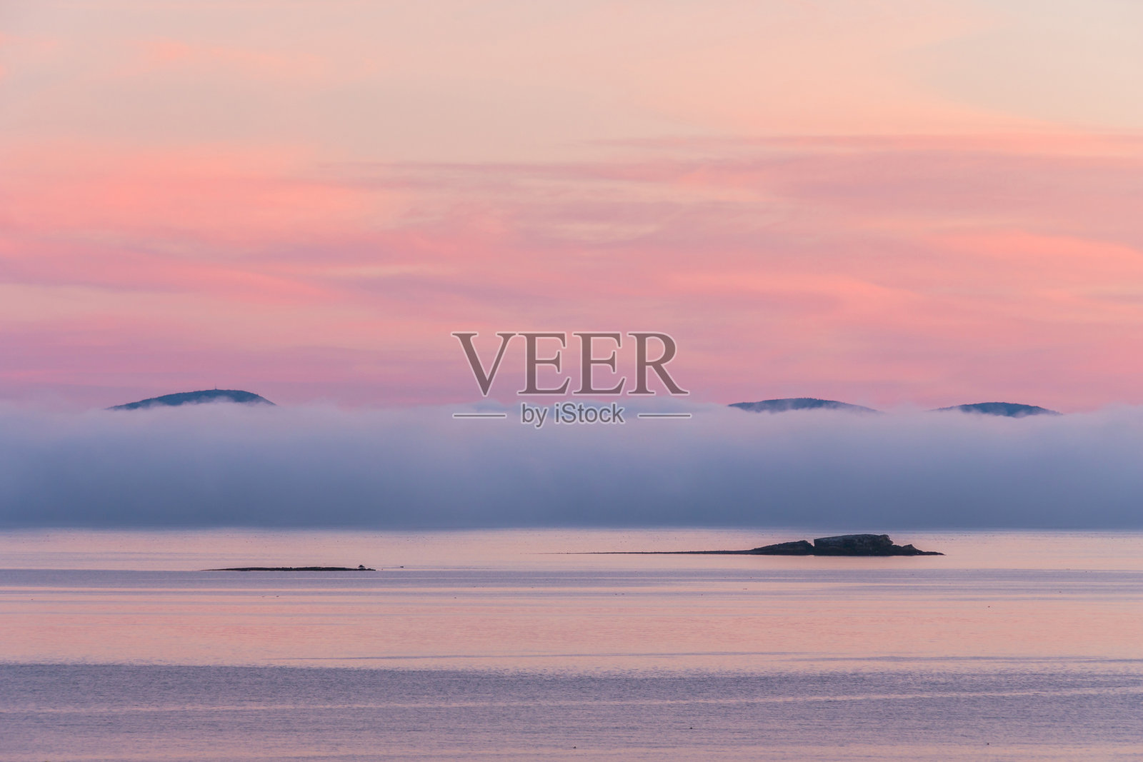 阿尔卑斯山的粉色晚霞,形成了如棉花糖般的天空,浓雾笼罩着远处的山脉,掩映在法国湾上。照片摄影图片