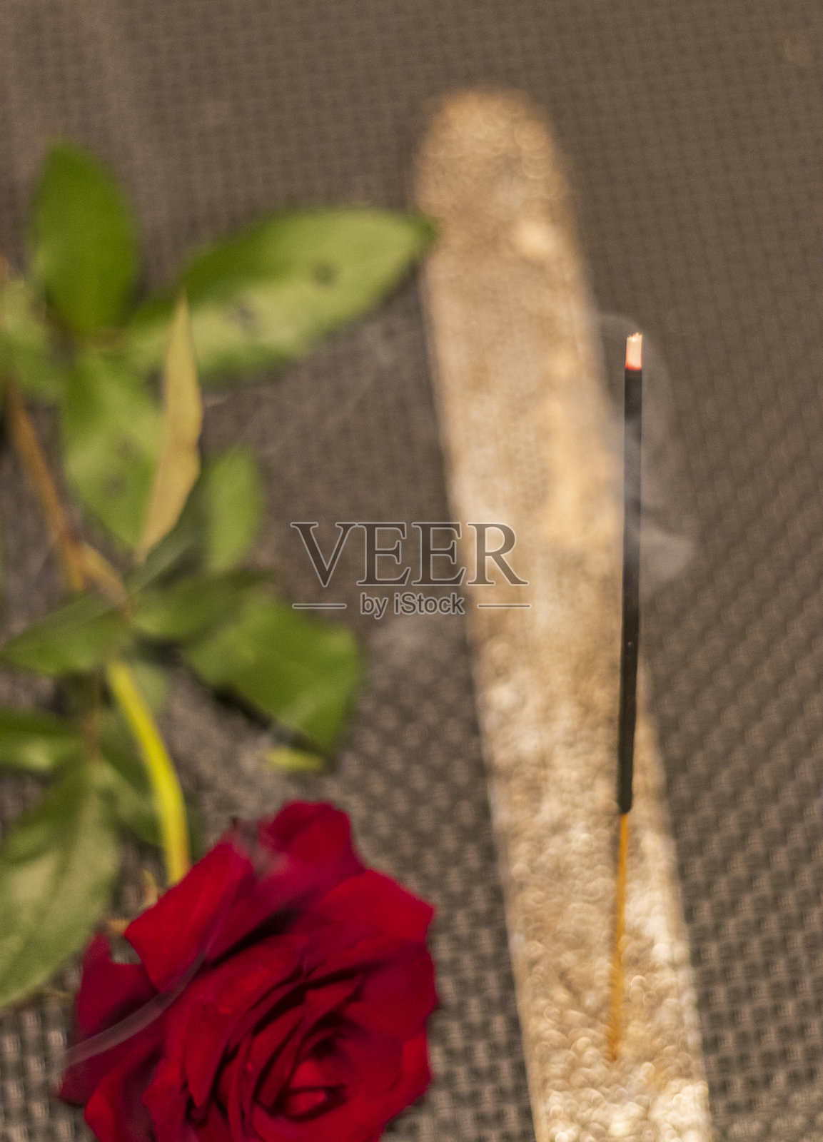 桌子上的燃烧香棒和玫瑰花的镜头。概念照片摄影图片